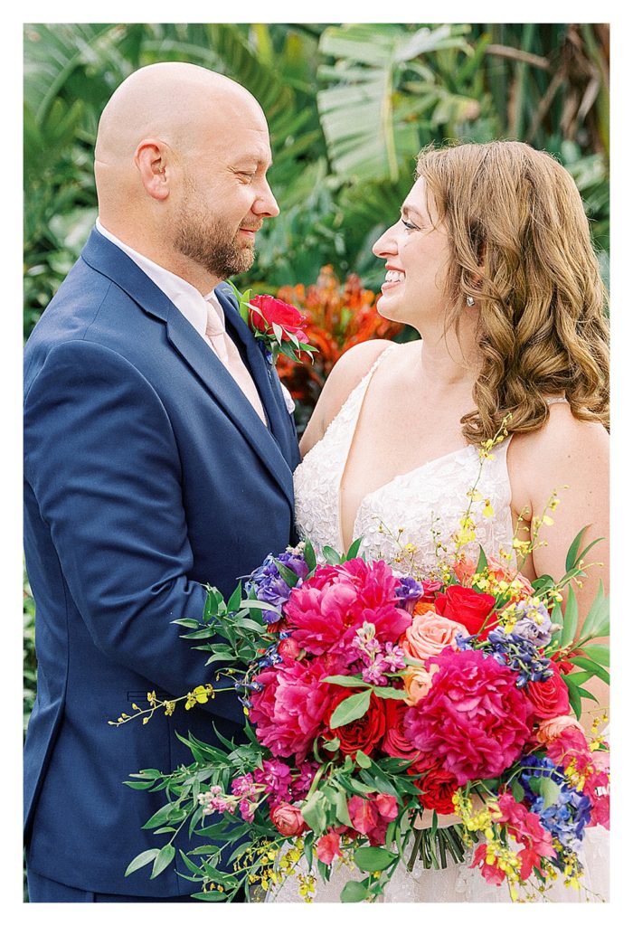 bride and groom at Walt Disney world with magenta and blue florals 