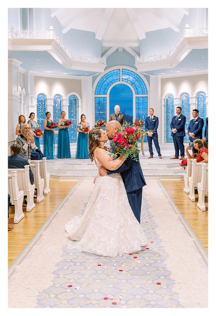 bride and groom kiss in the aisle of Disney's wedding pavilion 