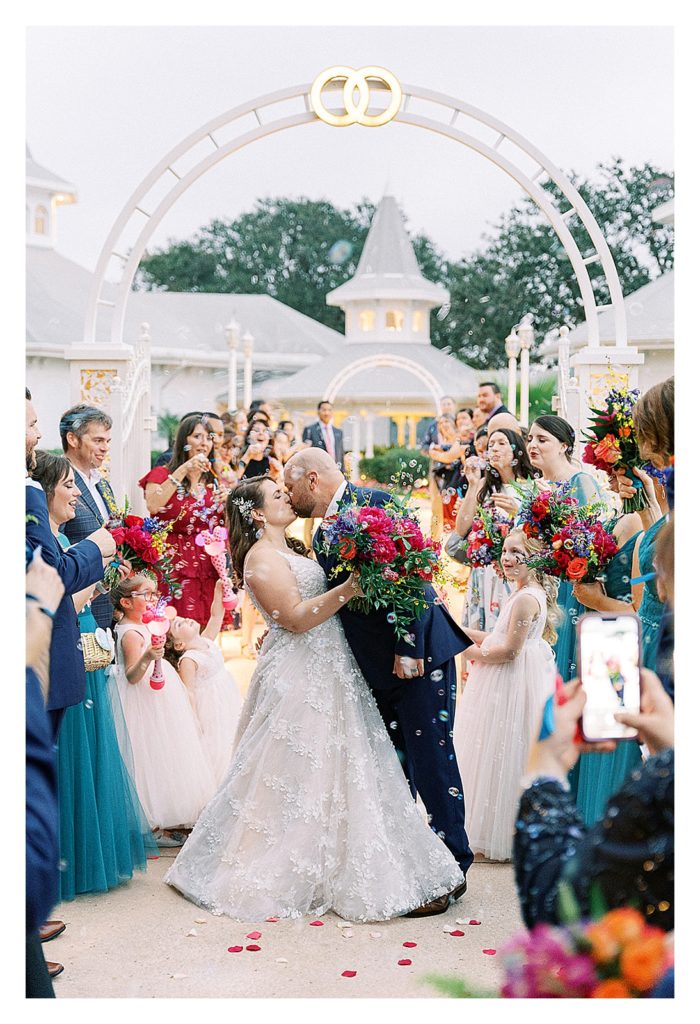 bride and groom grand exit with bubbles and magenta florals at Walt Disney World Wedding pavilion 