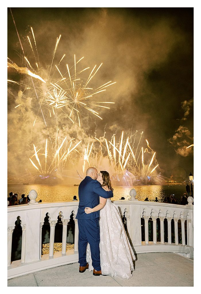 bride and groom kiss at the Epcot fireworks at their Disney wedding 