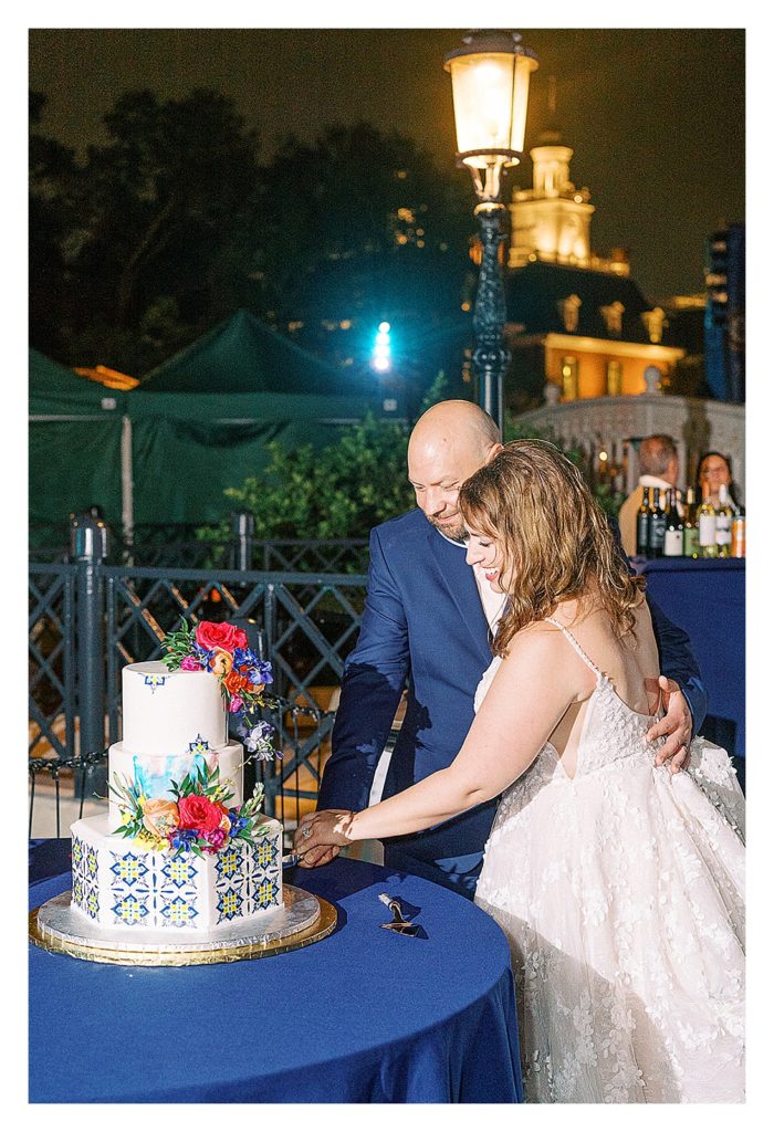 bride and groom cut an Italian tile inspired wedding cake at their Epcot Italy reception at Disney World 